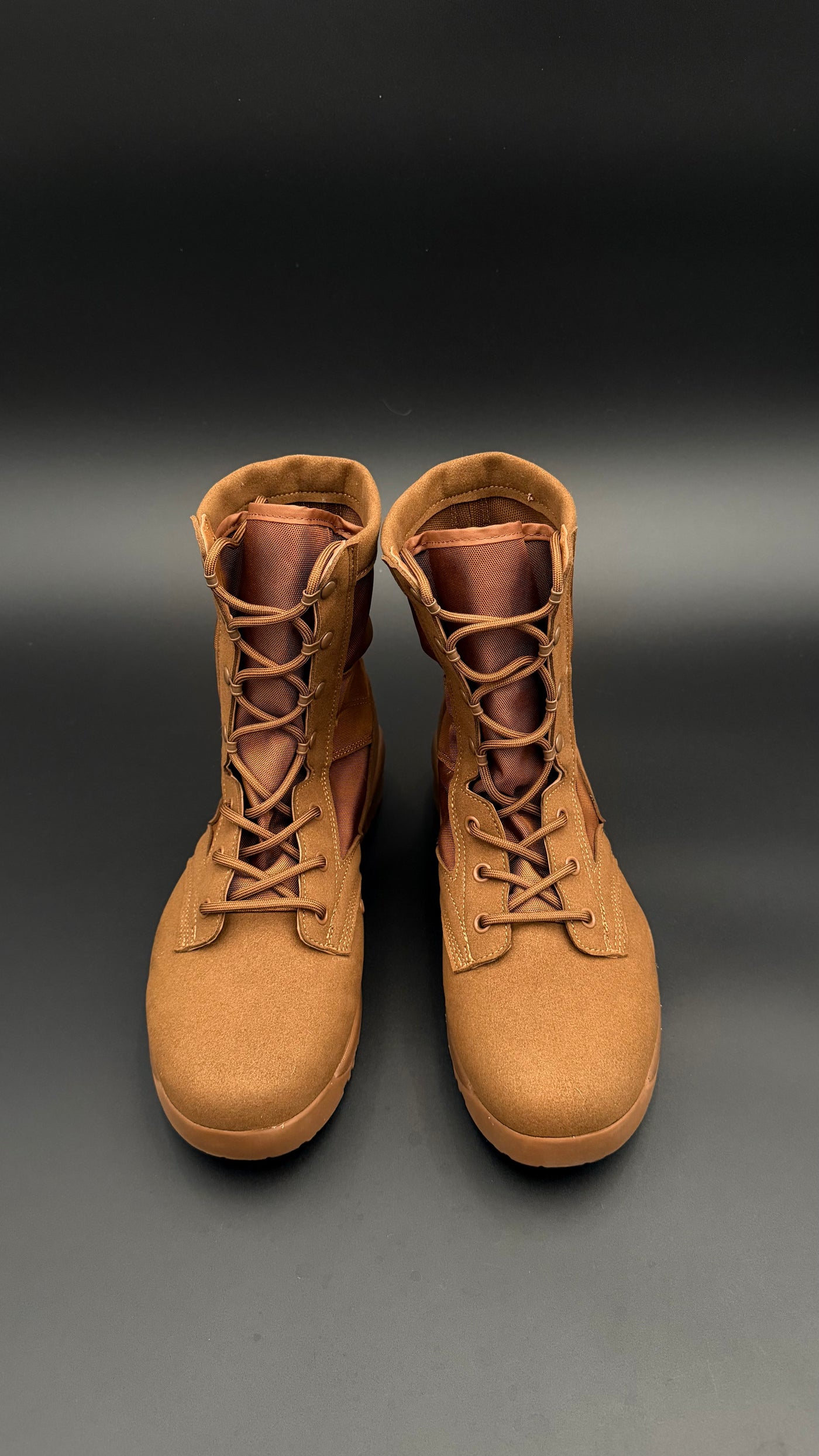 Pair of tan boots on a gradient black to gray background