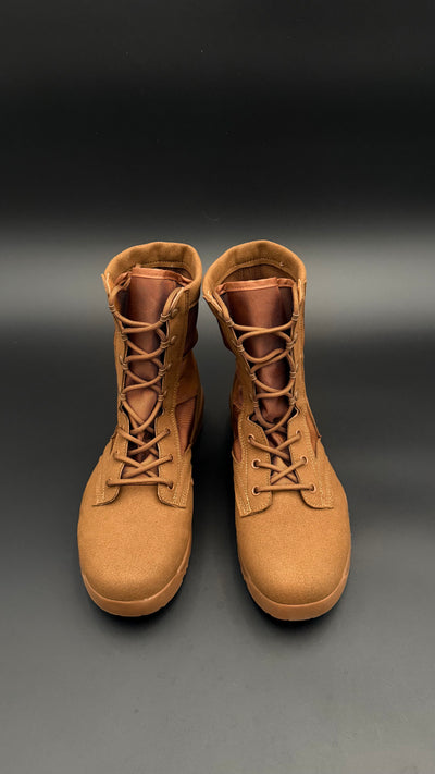 Pair of tan boots on a gradient black to gray background