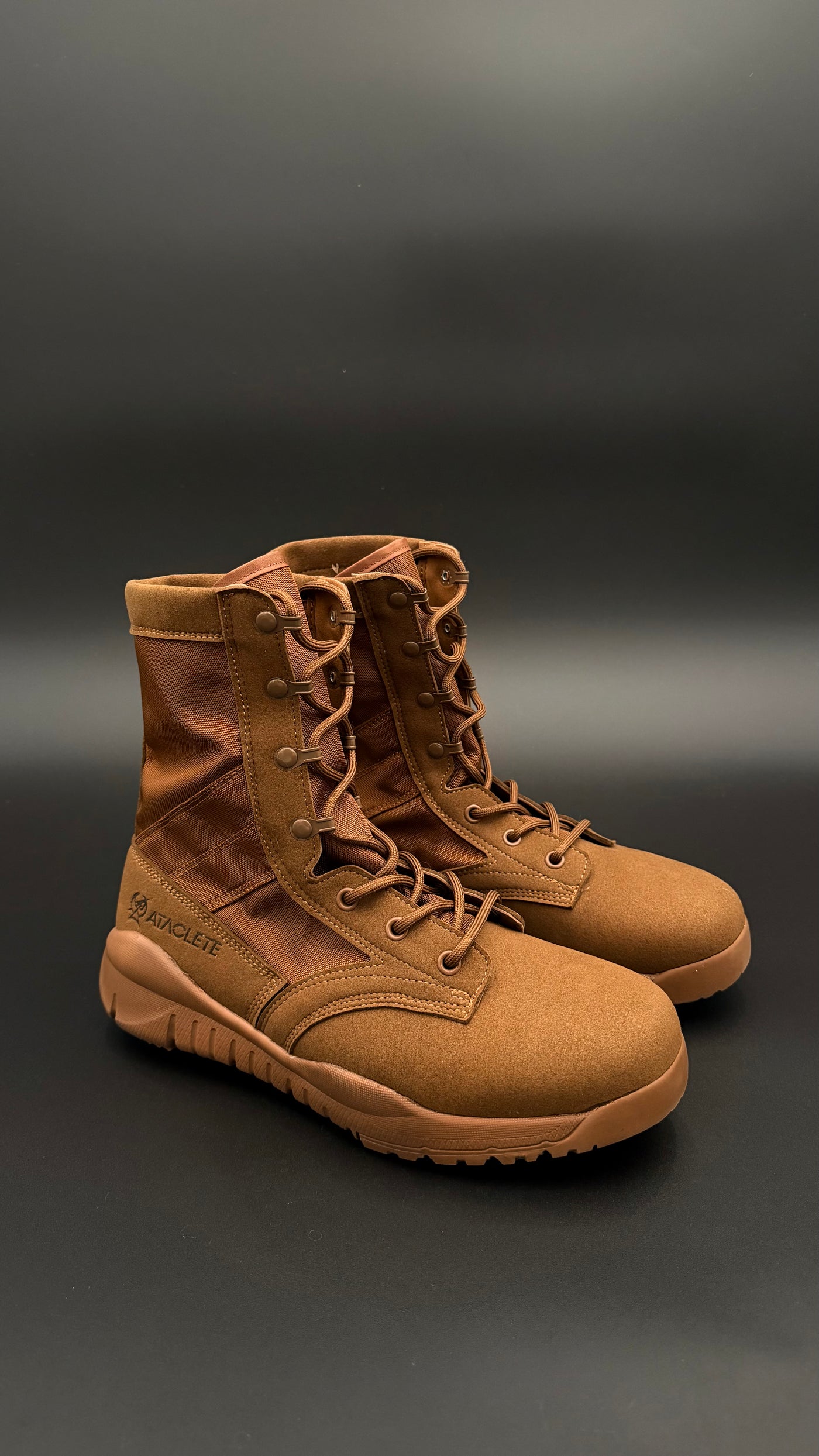Pair of brown tactical boots on a dark background